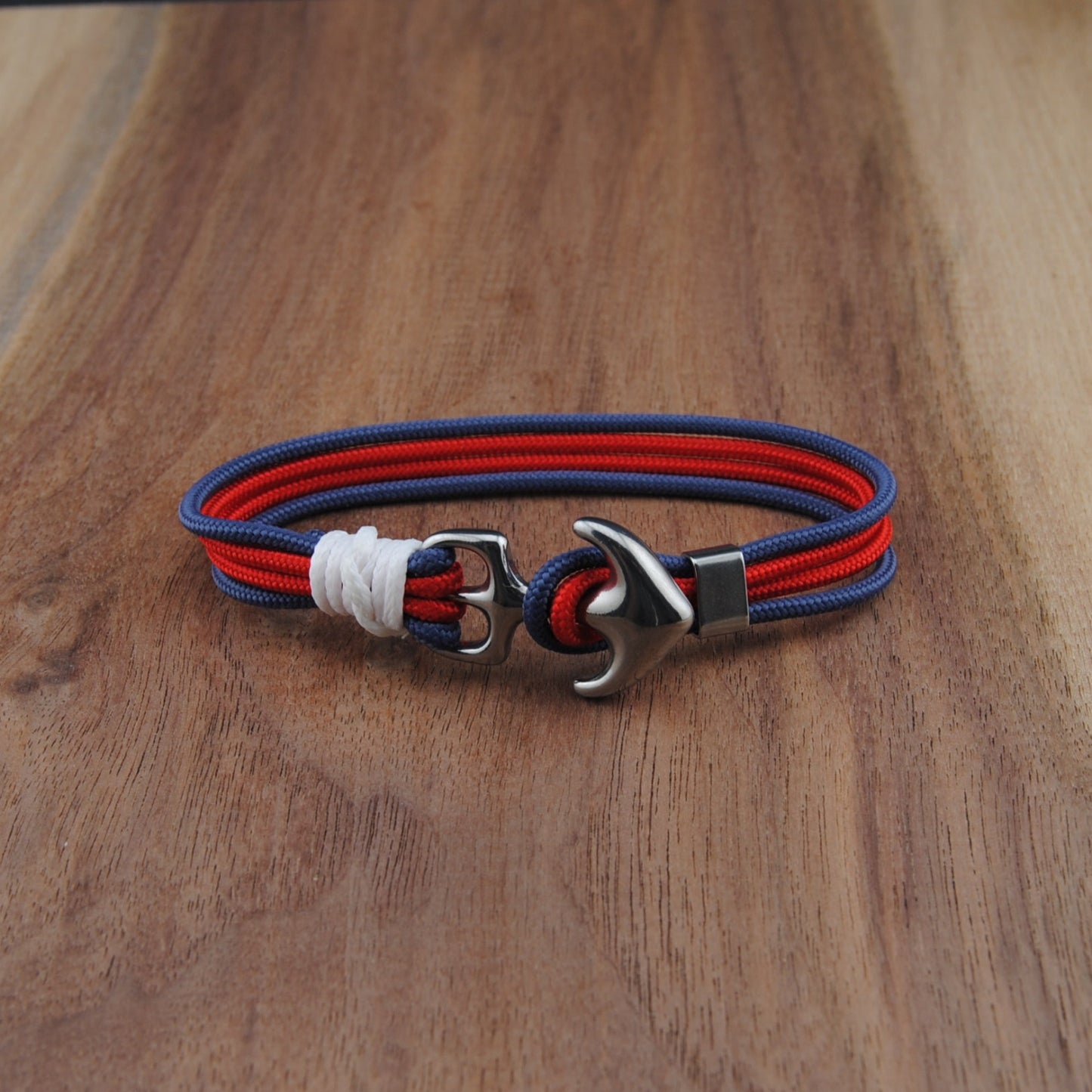 Bracelet with red and blue cord on a wooden surface