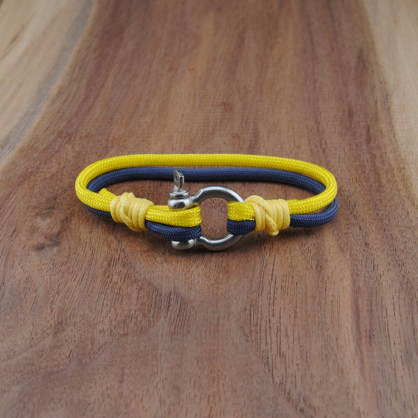 Yellow and blue bracelet with metal clasp on a wooden surface