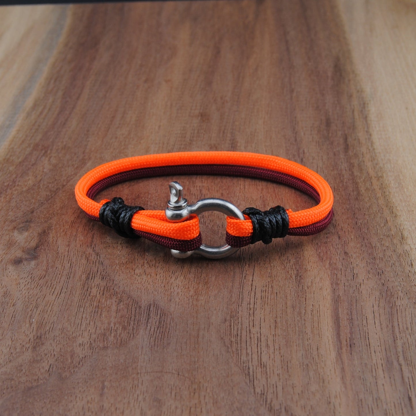 Orange and black bracelet on a wooden surface