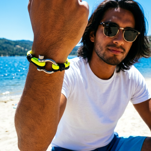 Man on a beach wearing a bracelet with a scenic background