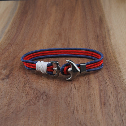 Bracelet with red and blue cord on a wooden surface