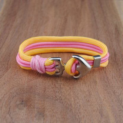 Pink and yellow bracelet with a silver clasp on a wooden surface
