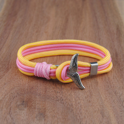 Yellow and pink bracelet with a stainless fishtail clasp on a wooden surface