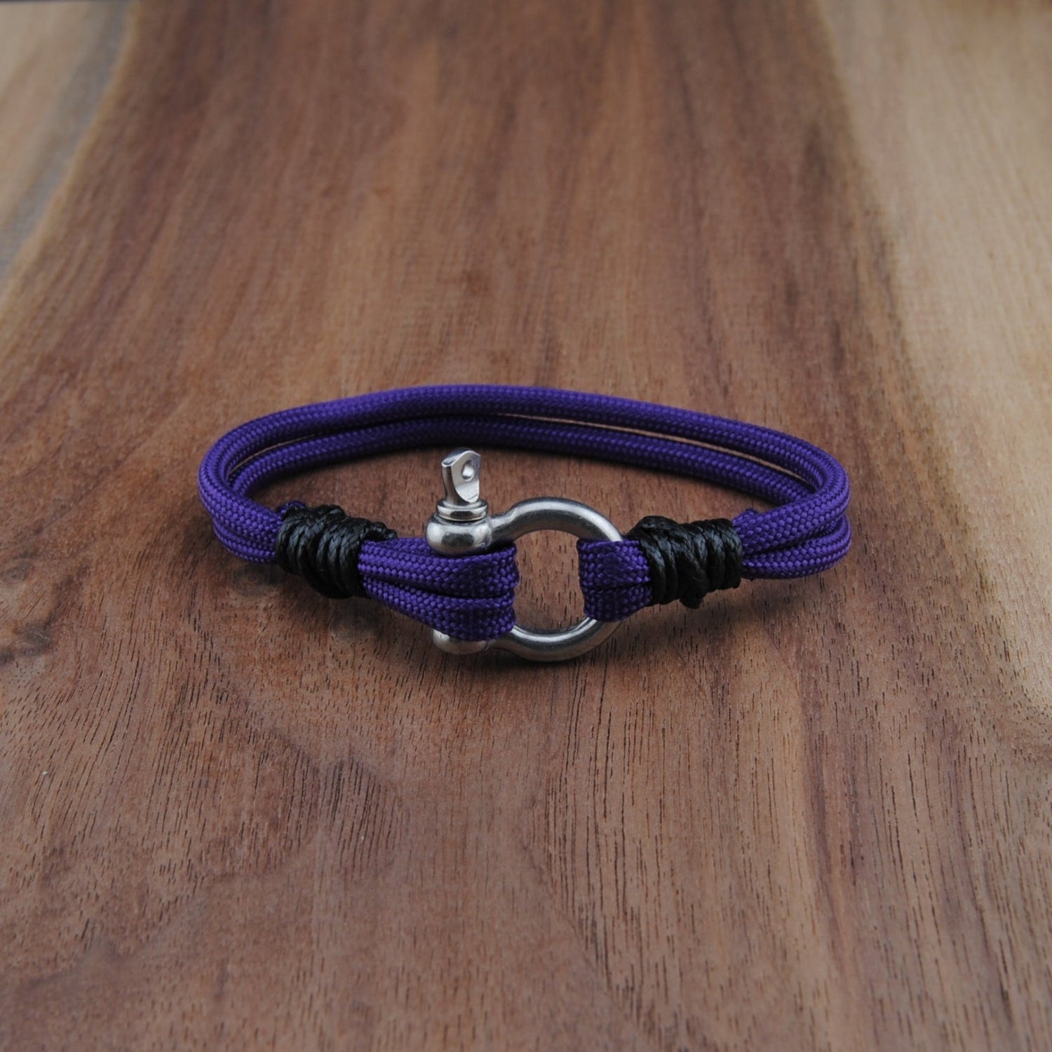Purple bracelet with a silver clasp on a wooden surface