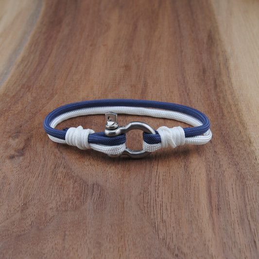 Nautical-style bracelet with blue and white cord on a wooden surface