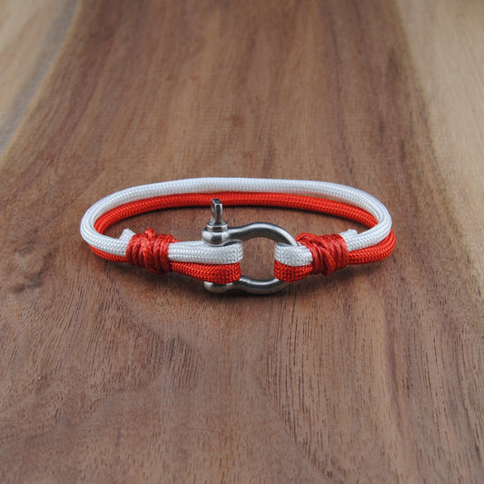 Bracelet with red and white cord on a wooden surface