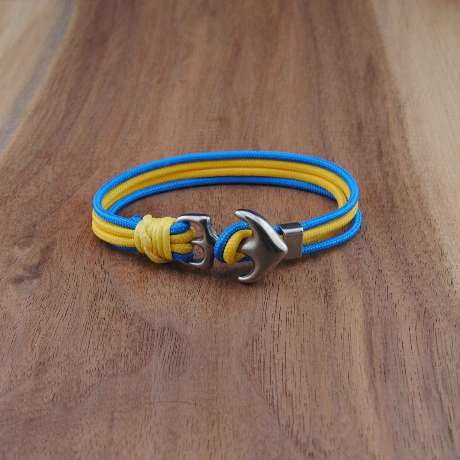 Yellow and blue bracelet with a silver clasp on a wooden surface