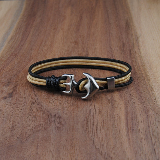 Bracelet with anchor charm on a wooden surface