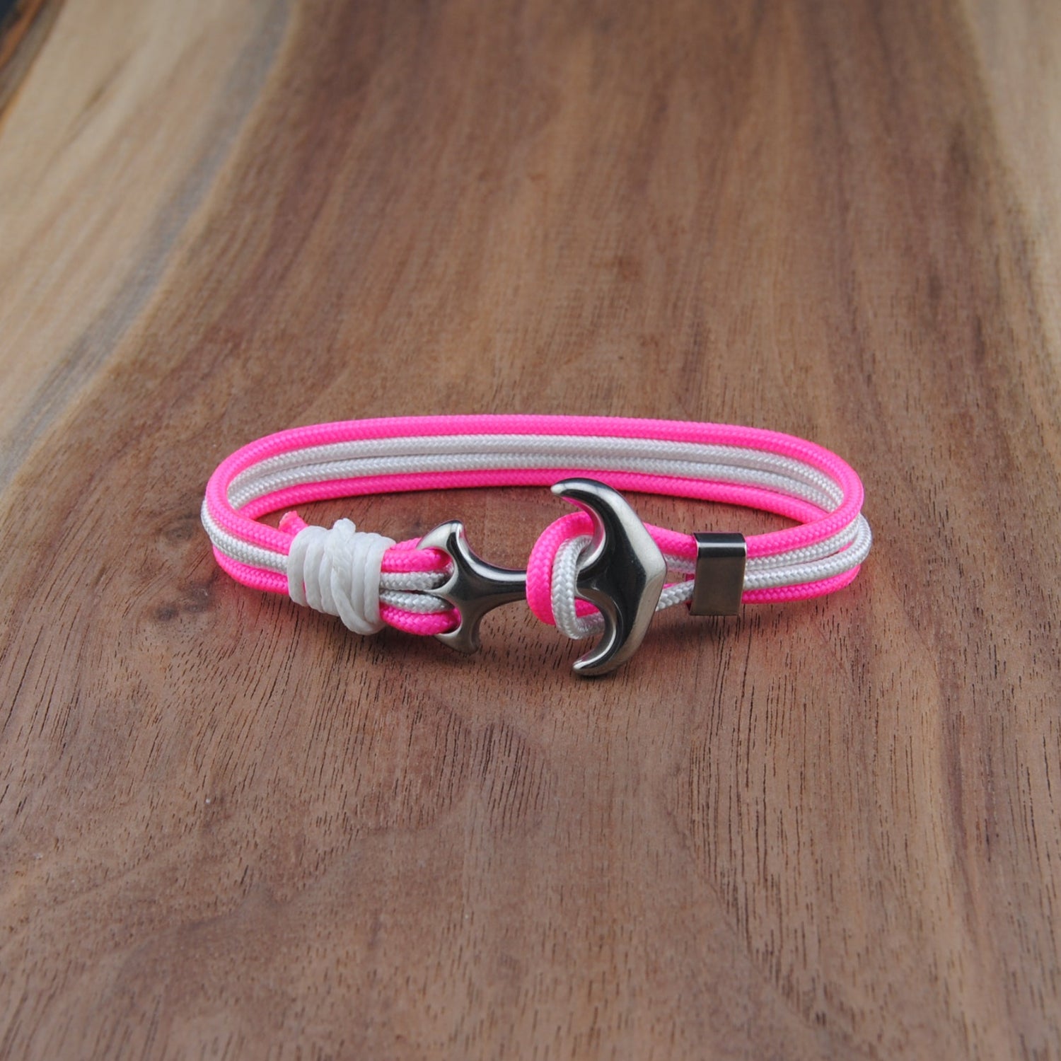 Bracelet with pink and white straps on a wooden surface
