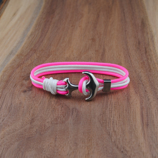 Bracelet with pink and white straps on a wooden surface