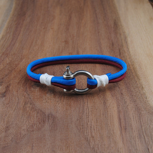 Bracelet with blue, red, and white bands on a wooden surface