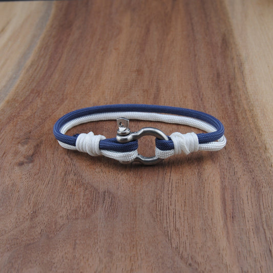 Nautical-style bracelet with blue and white cord on a wooden surface