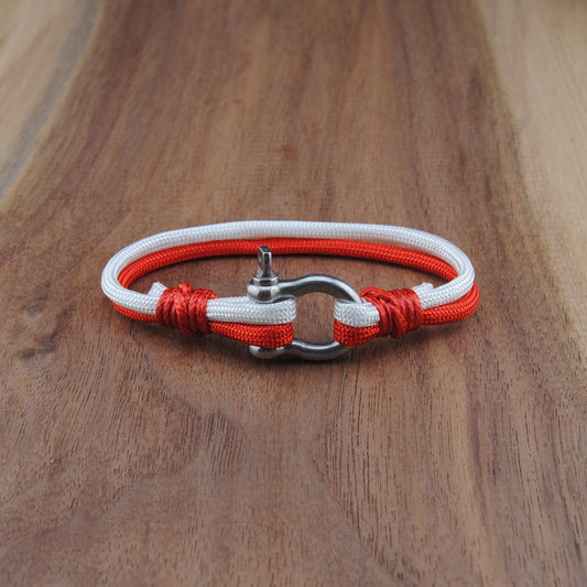 Bracelet with red and white cord on a wooden surface