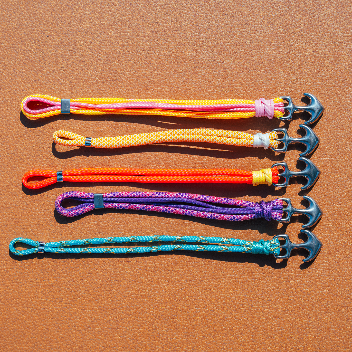Set of colorful paracord bracelets on a brown leather surface