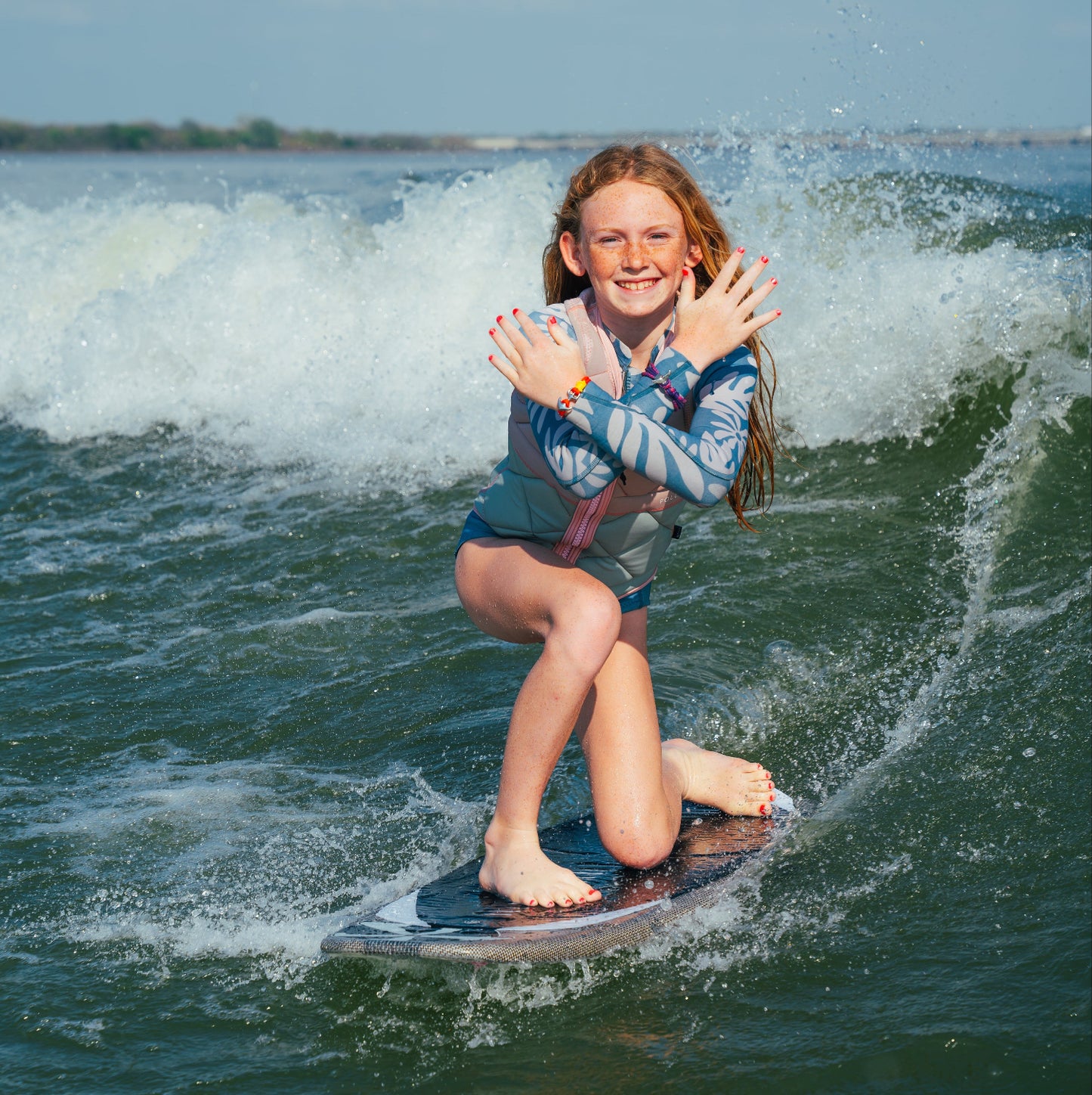 Young girl surfing on a wake