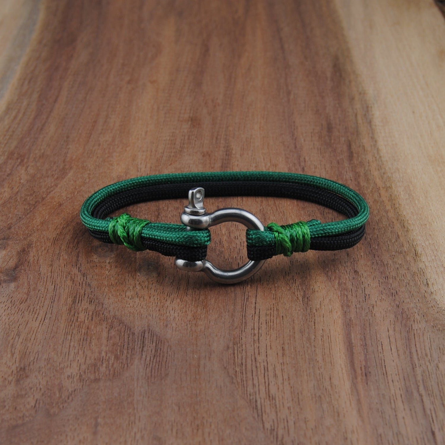 Green and black bracelet on a wooden surface