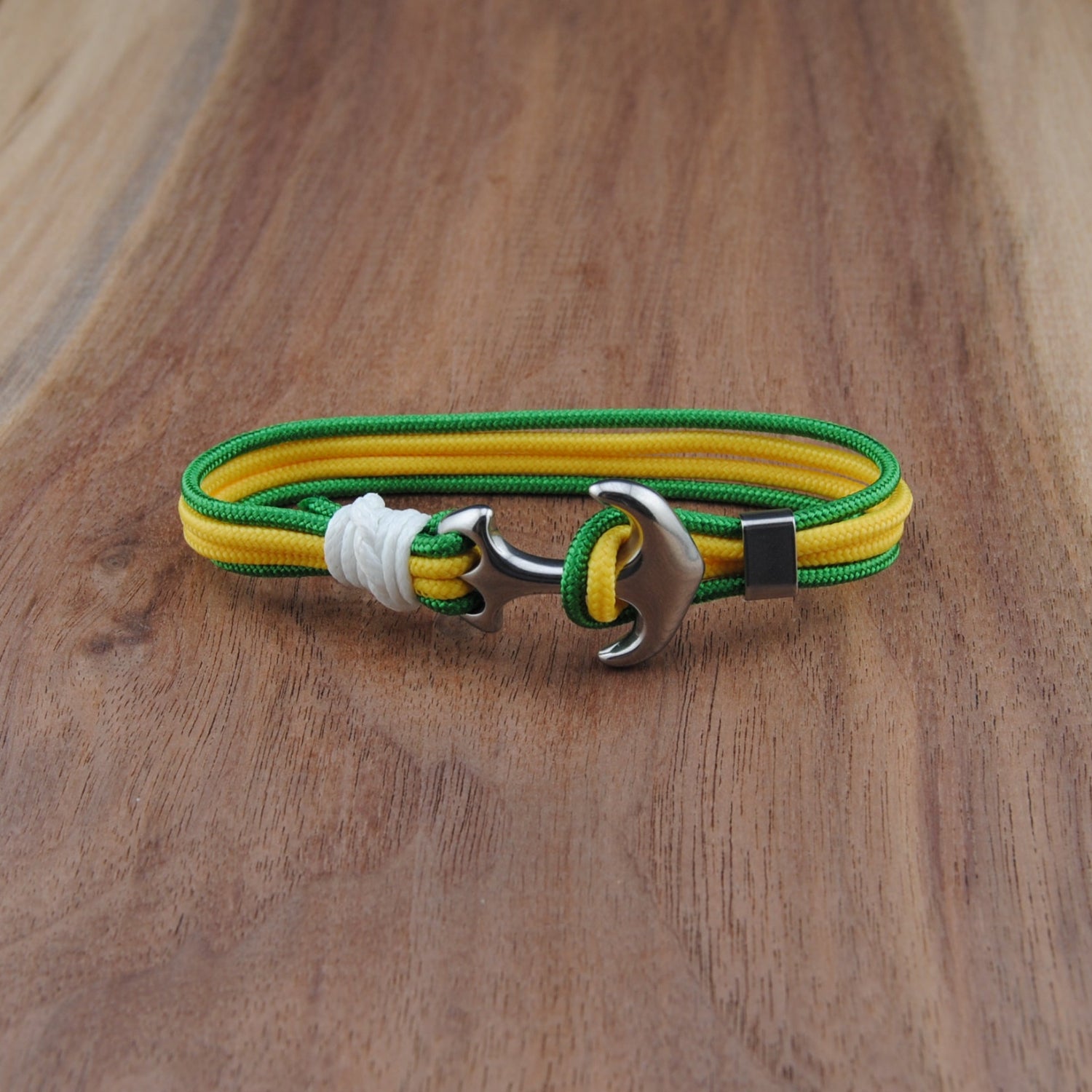 Yellow and green bracelet with a silver clasp on a wooden surface