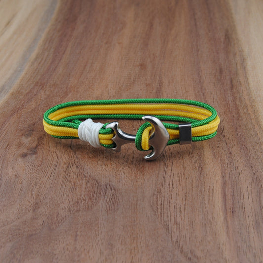 Yellow and green bracelet with a silver clasp on a wooden surface