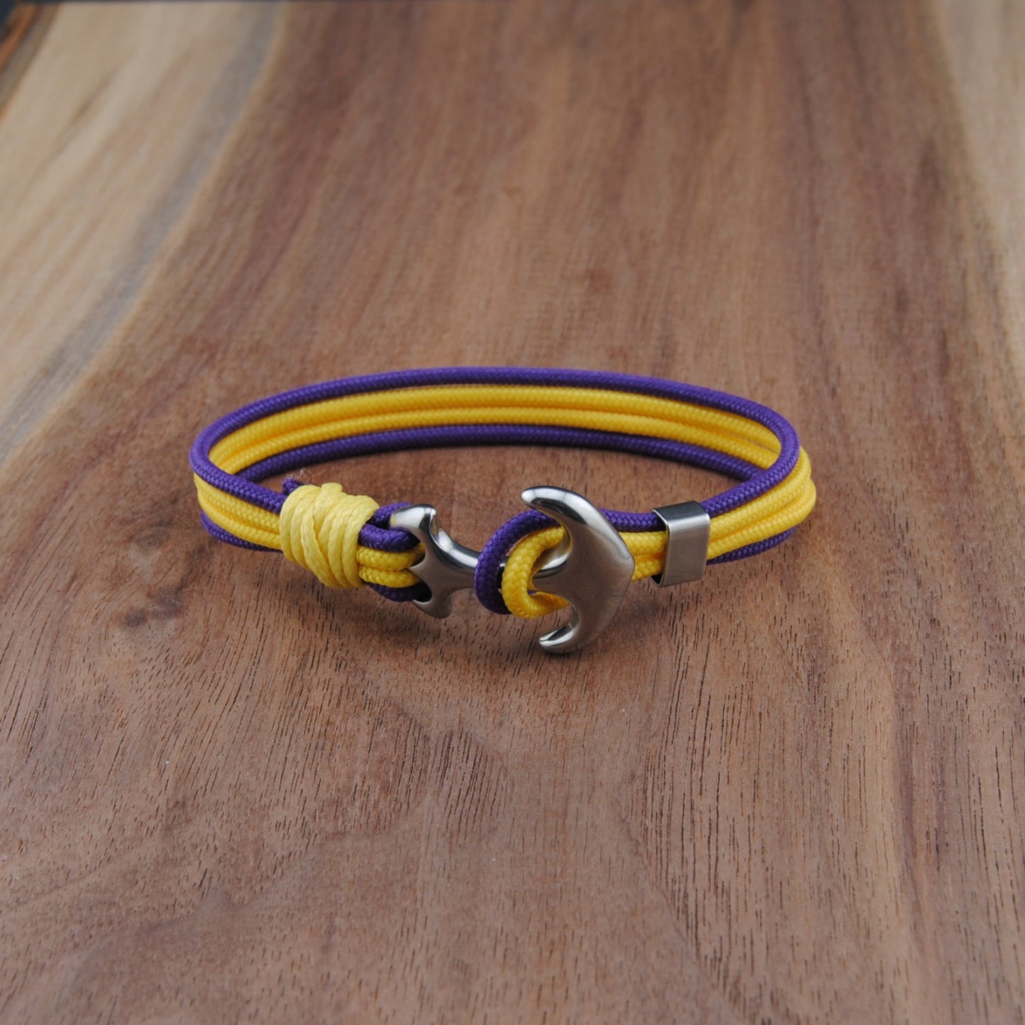 Yellow and purple bracelet with a metal clasp on a wooden surface