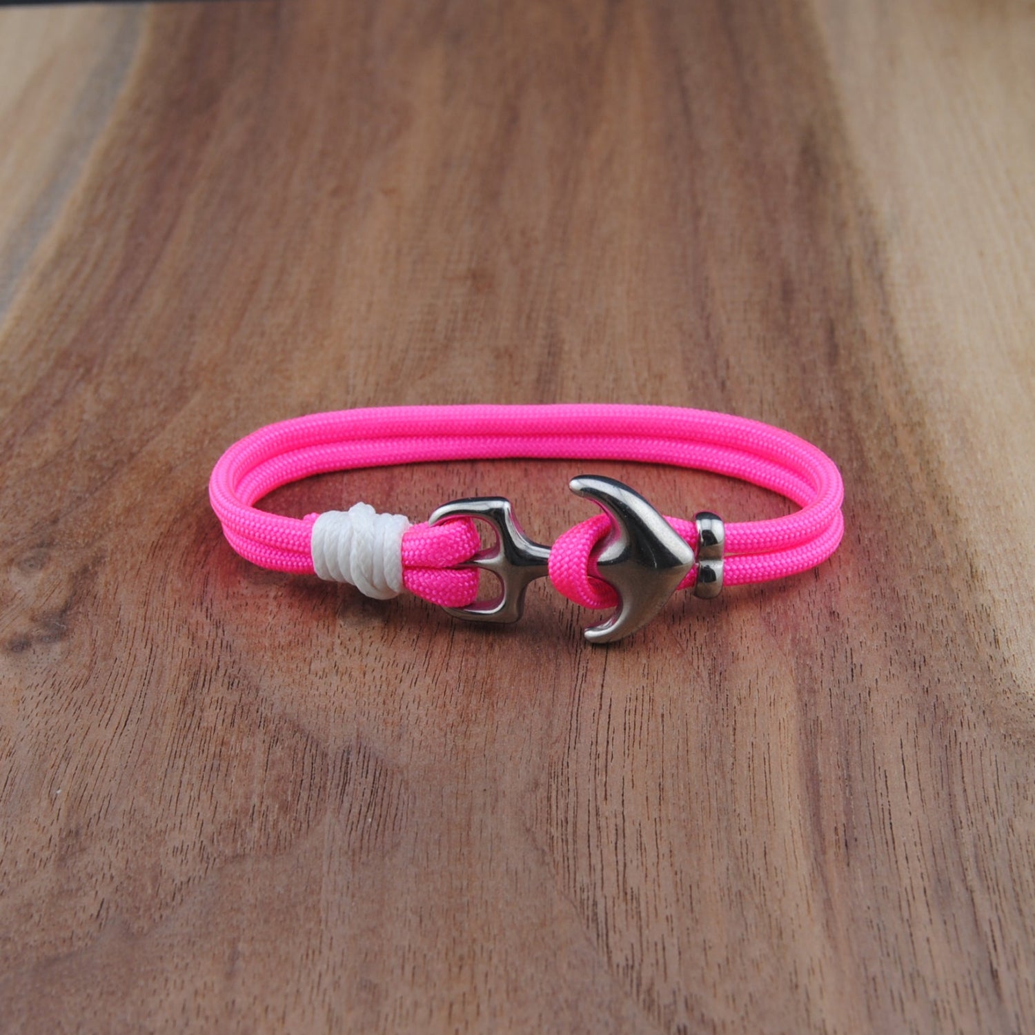 Pink bracelet with a silver clasp on a wooden surface