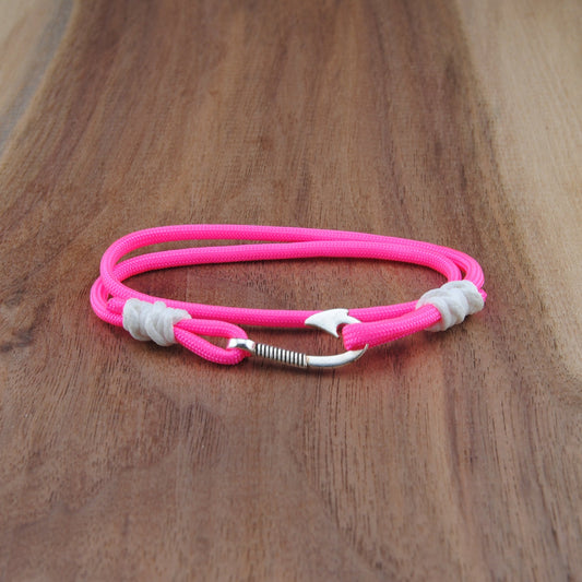 Pink bracelet with silver accents on a wooden surface