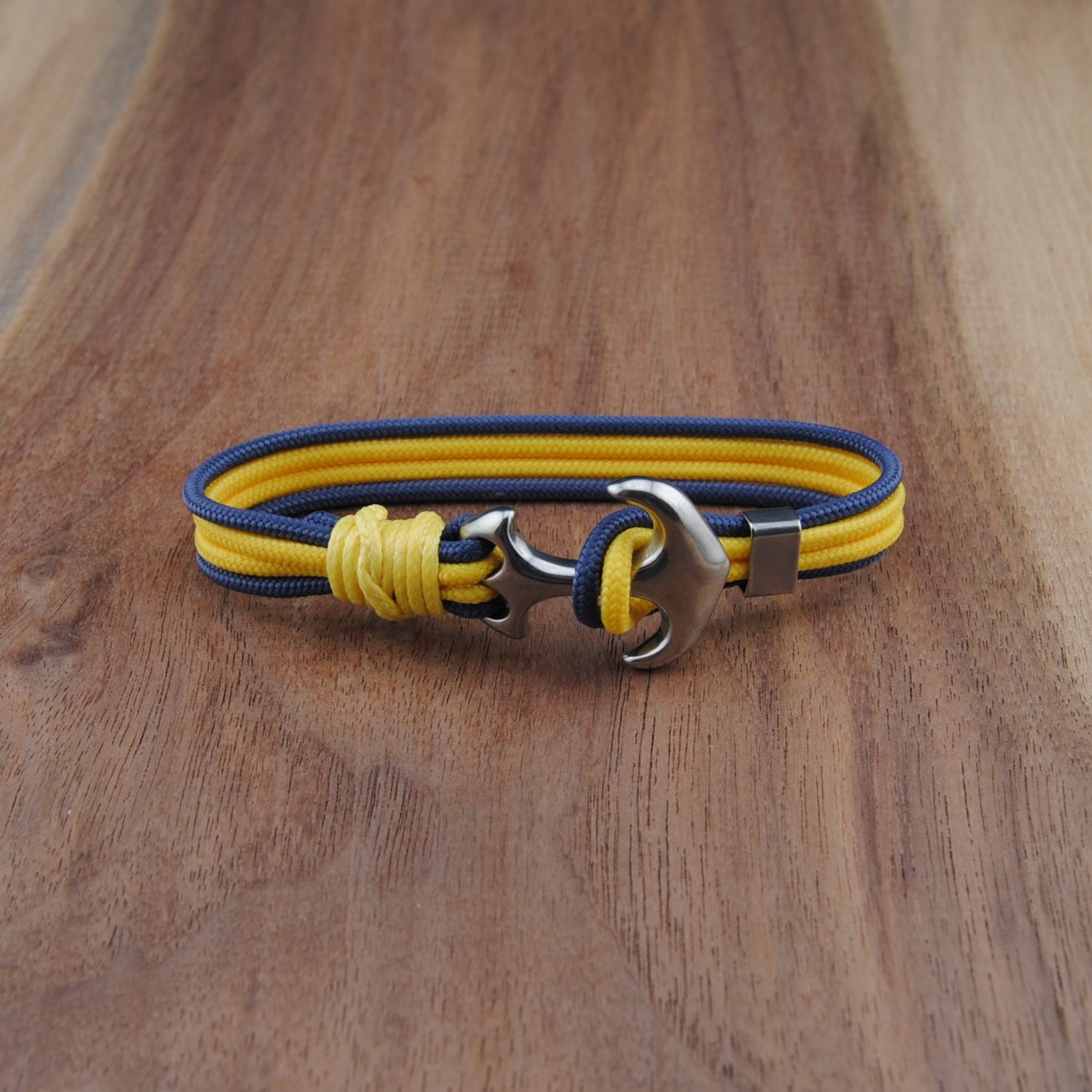 Yellow and blue bracelet with metal clasp on a wooden surface