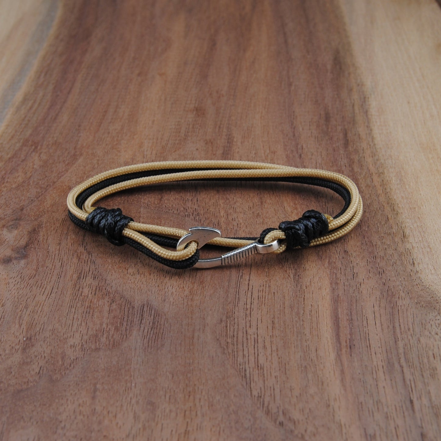 Bracelet with black and gold accents on a wooden surface