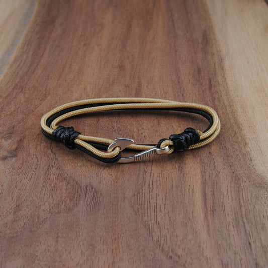 Bracelet with black and gold accents on a wooden surface