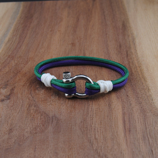 Bracelet with purple, green, and white bands on a wooden surface