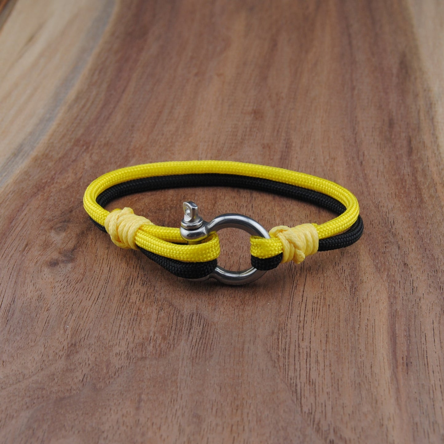 Yellow and black bracelet on a wooden surface