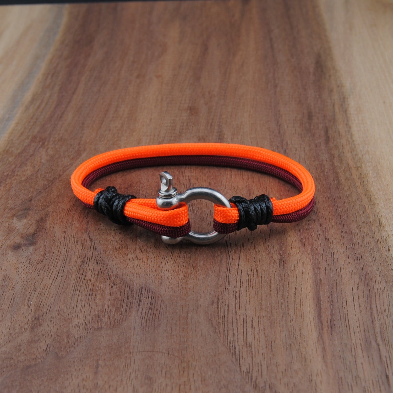 Orange and black bracelet on a wooden surface