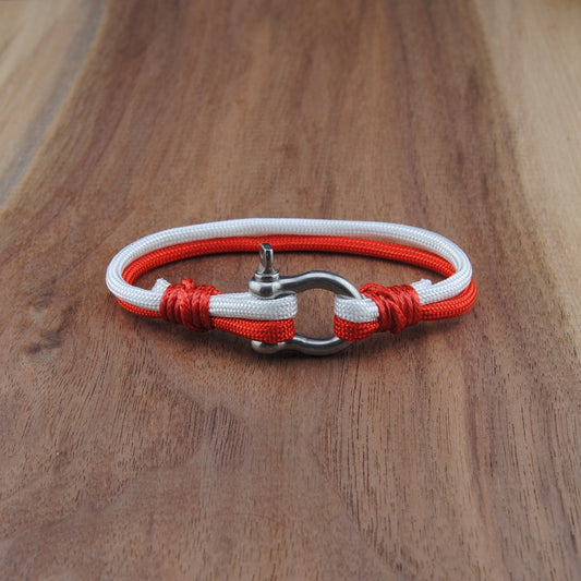 Bracelet with red and white cord on a wooden surface