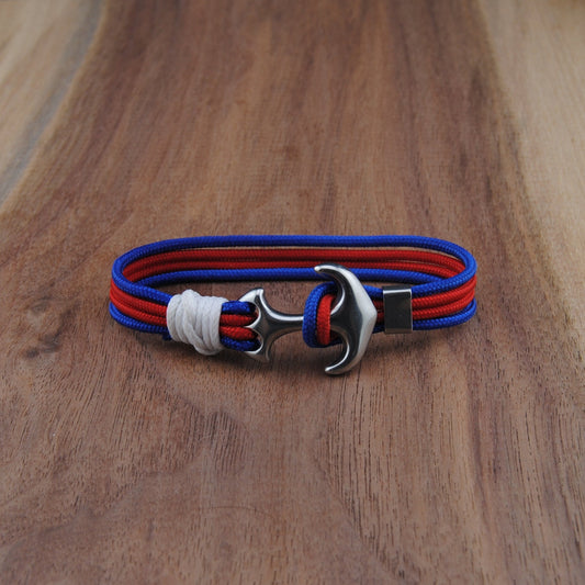 Bracelet with red and blue straps on a wooden surface