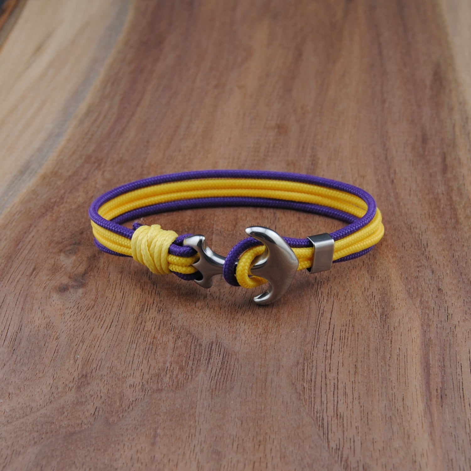 Yellow and purple bracelet with a metal clasp on a wooden surface