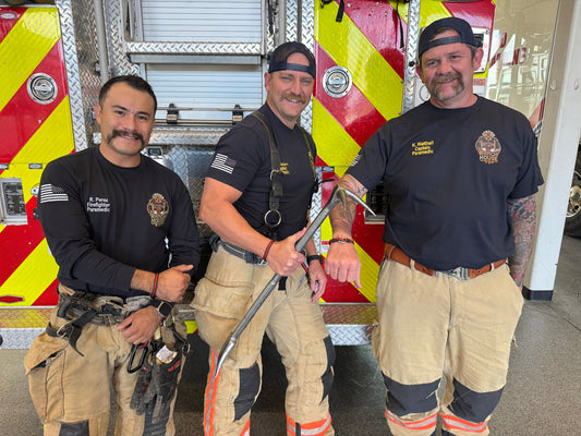 Three firefighters standing in front of a fire truck
