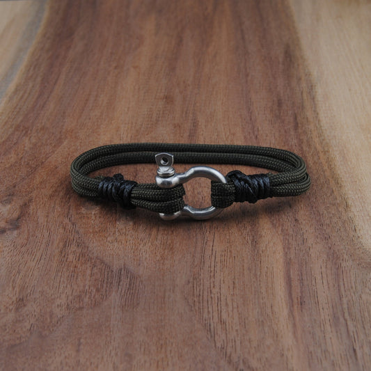 Army Green bracelet with metal clasp on a wooden surface