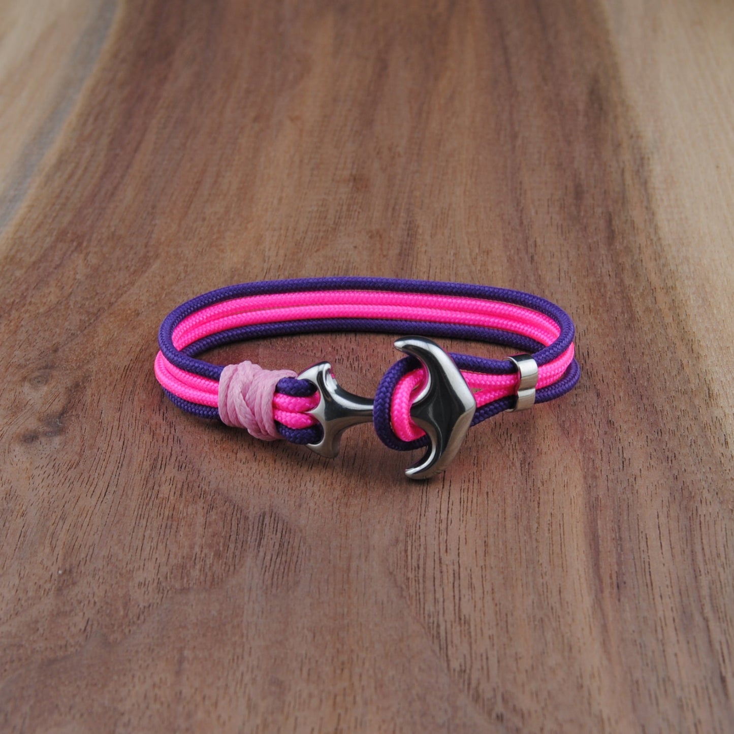 Pink and purple bracelet with a silver clasp on a wooden surface