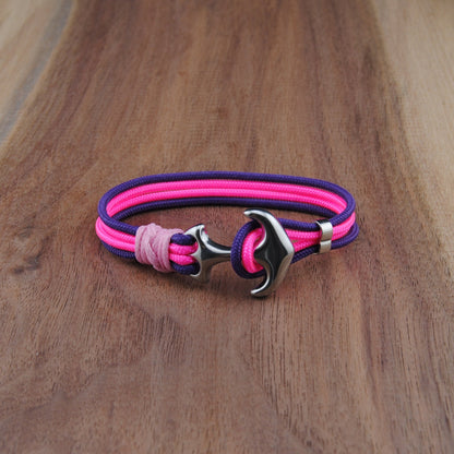 Pink and purple bracelet with a silver clasp on a wooden surface