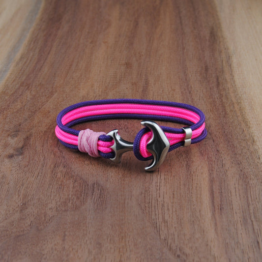 Pink and purple bracelet with a silver clasp on a wooden surface