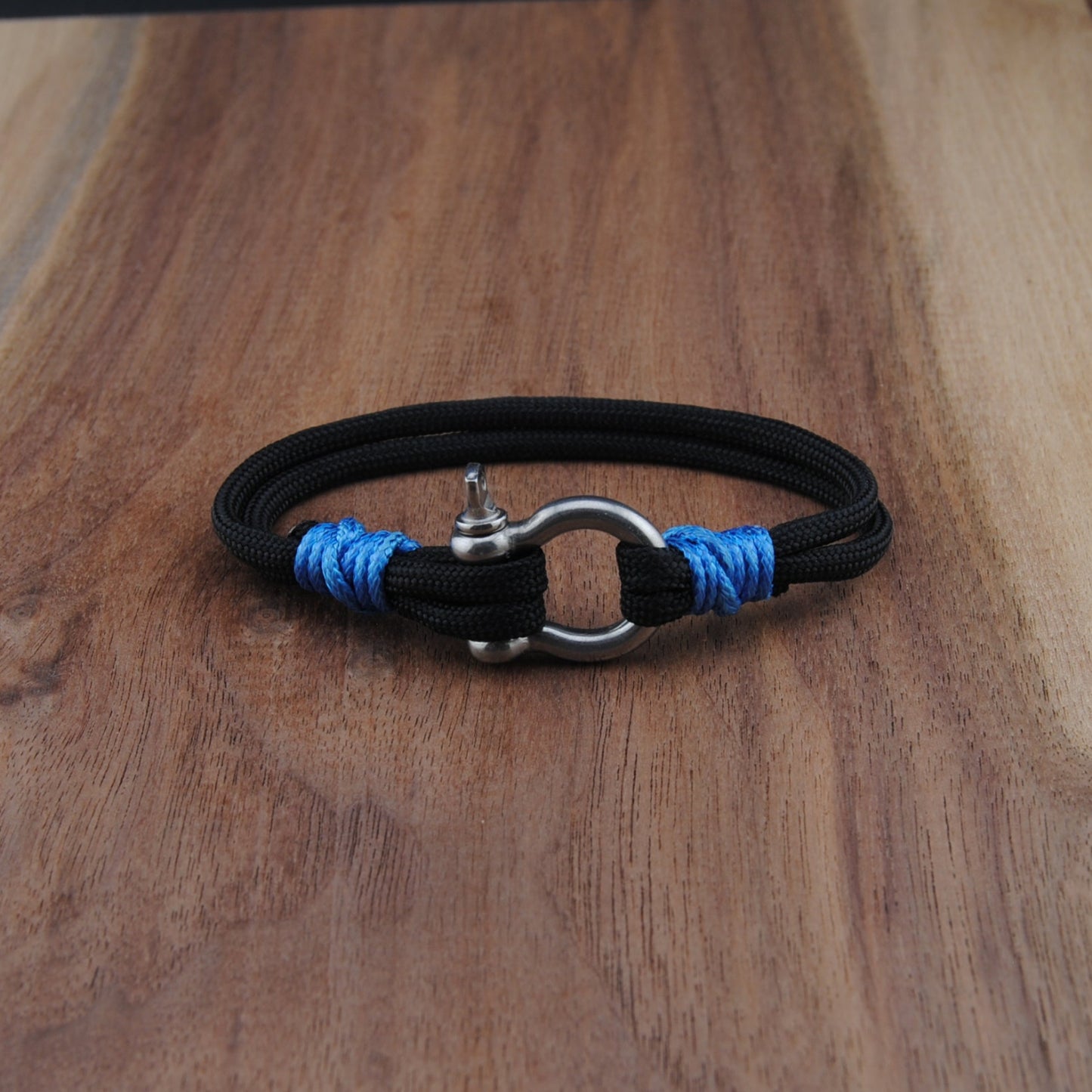 Black bracelet with blue accents on a wooden surface