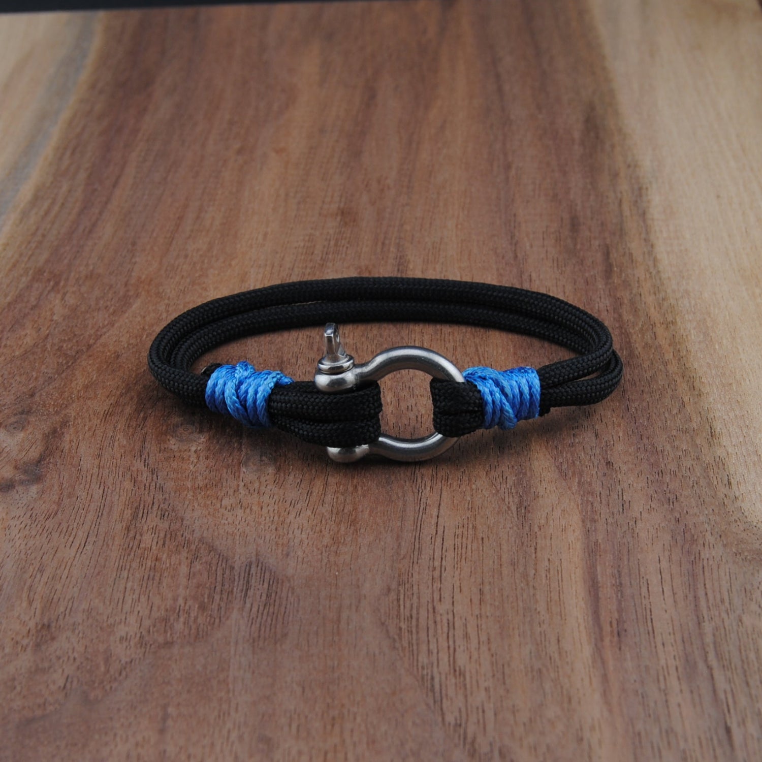Black bracelet with blue accents on a wooden surface