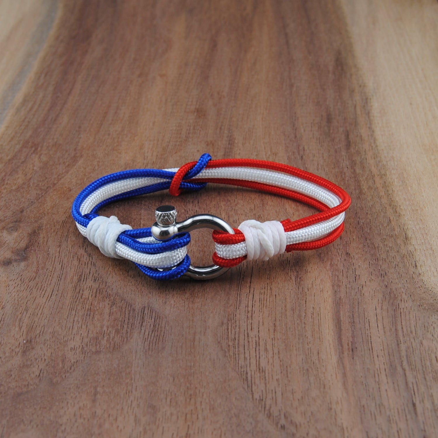 Bracelet with red, white, and blue ropes on a wooden surface