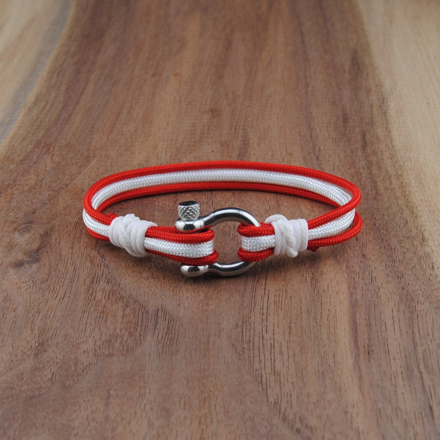 Red and white bracelet with metal clasp on a wooden surface