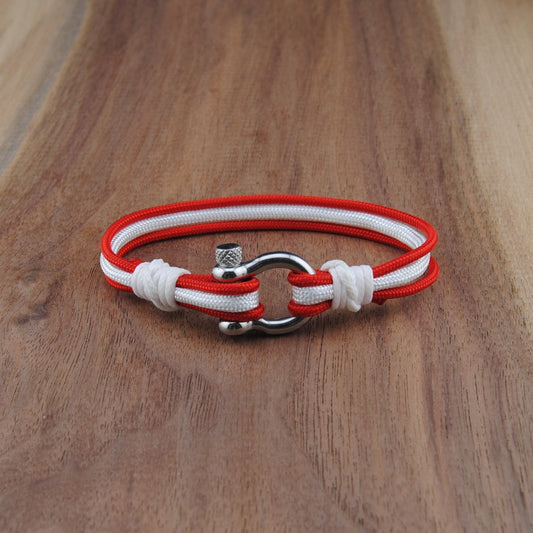 Red and white bracelet with metal clasp on a wooden surface