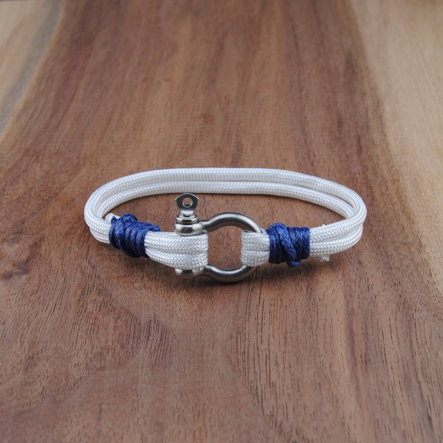 White bracelet with blue accents on a wooden surface