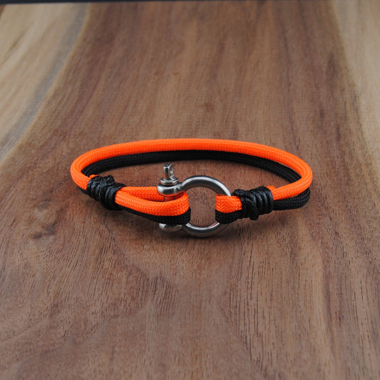 Neon orange and black bracelet on a wooden surface