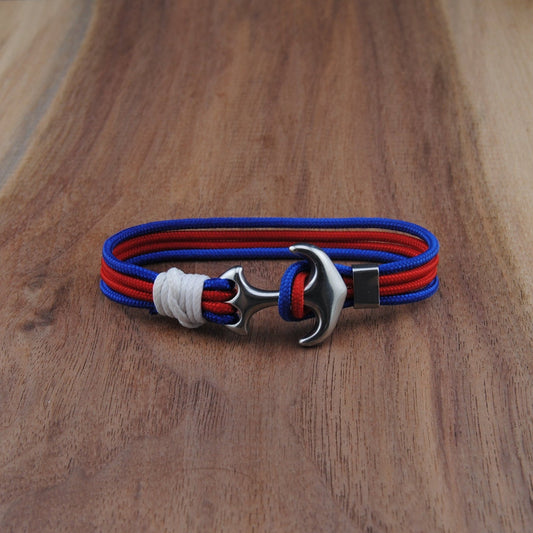 Bracelet with red and blue straps on a wooden surface