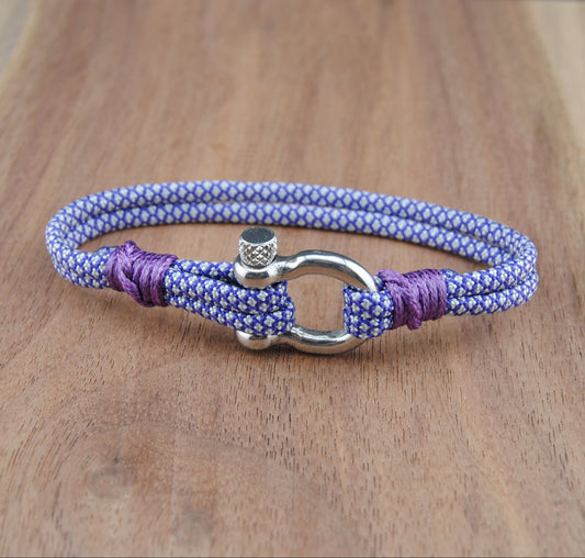 Purple and blue braided bracelet with a silver clasp on a wooden surface