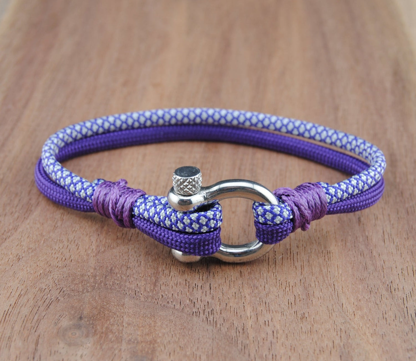 Purple and White bracelet with a metal clasp on a wooden surface