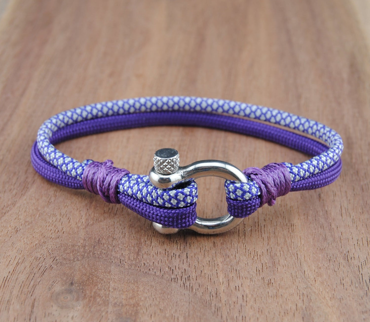 Purple and White bracelet with a metal clasp on a wooden surface